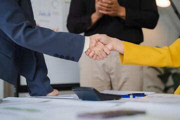 Handshake Deal: Two business professionals seal a deal with a firm handshake, signifying trust,...