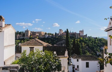Alhambra of Granada, view between the streets and houses of the city, in an autumn sunset, Andalusia, Spain