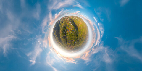 Green little planet with trees and field. Tiny planet with blue sky and sun. 360 viewing angle.
