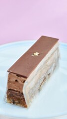Chocolate Pastry with Gold Decoration on Plate and Lilac Background