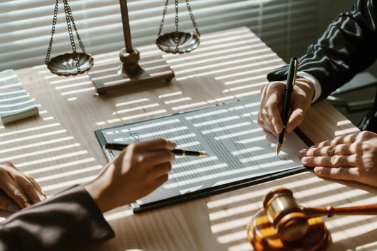Lawyers are reviewing and signing important documents for a client in their law office