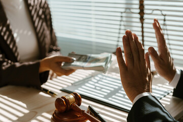 Businessman is refusing to take bribe money from a businesswoman in a legal setting