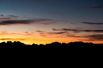 Paisaje esperanzador de siluetas de montañas con un amanecer naranja
