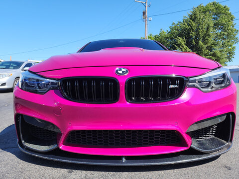 Seattle, WA, USA -July 19, 2024 : BMW F82 M4 Competition pink color front view. BMW F82 M4 is the sport version of BMW car.