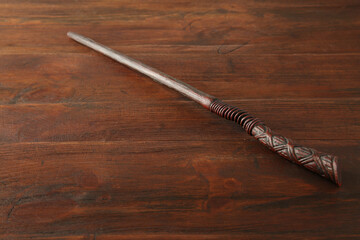 One old magic wand on wooden table, closeup