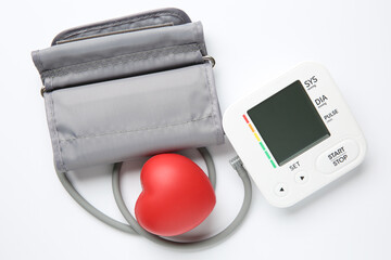 Blood pressure measuring device and squeeze heart on white background, top view