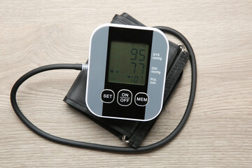 Blood pressure measuring device on wooden table, top view