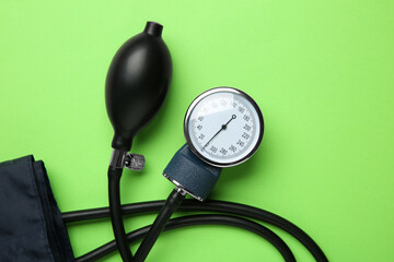 Blood pressure measuring device on green background, top view