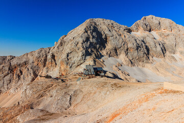 Triglav mountain hut with triglav mountain at the morning sun 