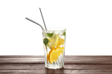 Glass of tasty refreshing drink and straws on wooden table against white background