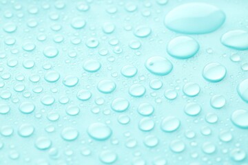 Water drops on turquoise background, closeup view