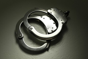 Classic chain handcuffs on grey table, closeup