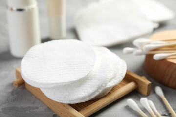 Clean cotton pads and swabs on grey table, closeup