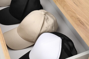 Stylish baseball caps in chest of drawers. Mockup for design