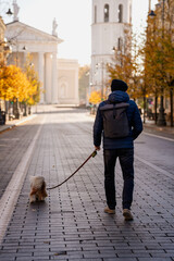 Man Walking Dog on Empty City Street with Cathedral in Background