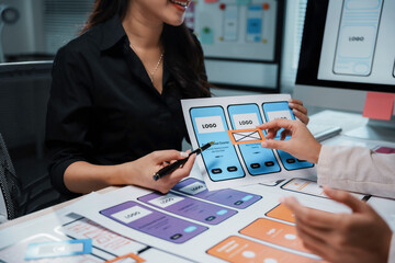 User experience designers are discussing about the layout of a mobile application for smartphones