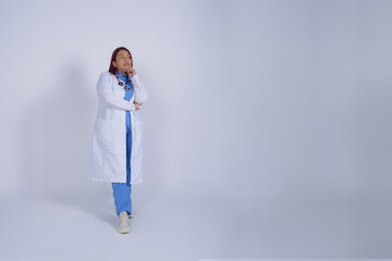 Female doctor standing thinking over a diagnosis, copy space, white background, studio shot.