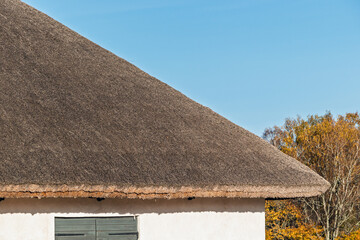 Thatched roof, thatching. White stone house with thatched roof close-up