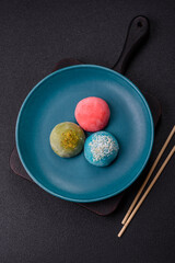Delicious colorful asian mochi sweets with rice dough shell and fruit filling