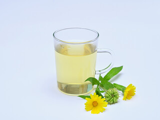 herbal tea from calendula and yellow flowers nearby on a white background