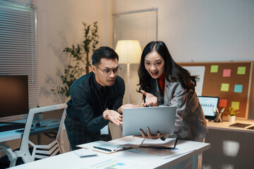 Two business partners looking concerned having a disagreement while working late night in the office