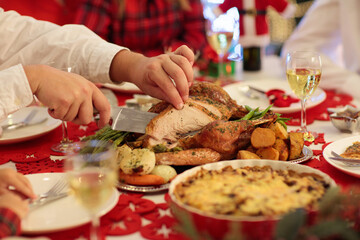 Family with kids having Christmas dinner at tree