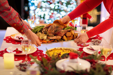 Family with kids having Christmas dinner at tree