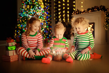 Child decorating Christmas tree. Kid on Xmas eve.