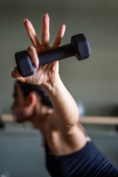 Woman lifting small weights in barre class