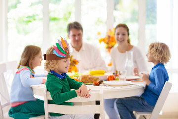 Family with kids at Thanksgiving dinner. Turkey.