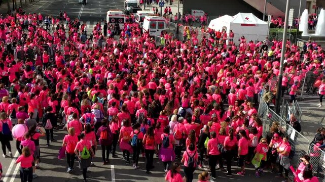 BARCELONA, SPAIN - CIRCA NOVEMBER 2016, Women gathered at the start line of a massive feminist awareness run in Barcelona, wearing pink shirts and preparing for a day of unity