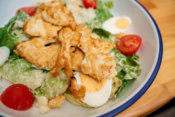 Caesar salad with chicken on a plate.