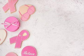 Pink cookies with ribbons and gift box on white grunge background. Breast cancer awareness concept