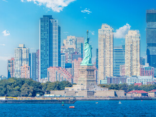 Naklejka premium Statue of Liberty with some skyscrapers on the background