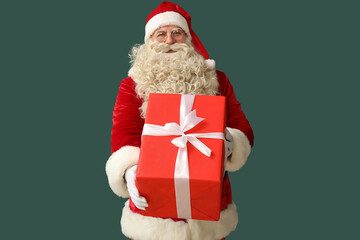 Santa Claus with Christmas gift on green background