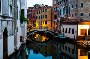 Scenic canal with ancient buildings and bridge in the morning in Venice, Italy.