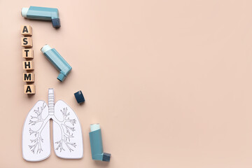 Inhalers, paper lungs and wooden cubes with text ASTHMA on beige background