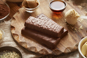 Whey protein powder, maple syrup, peanut and cocoa butter, raw cacao and hemp seeds - ingredients for whey protein chocolate bars