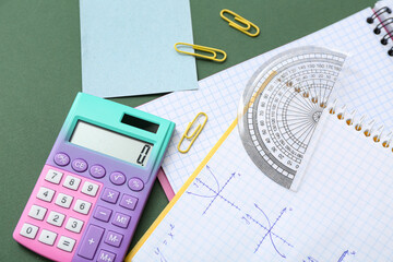 Notebooks with calculator and school stationery on chalkboard