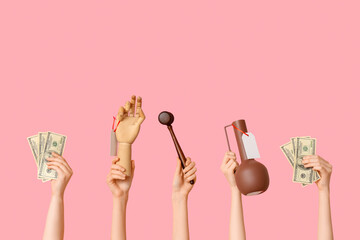 Female hands with auction gavel, dollar banknotes and antique items on pink background