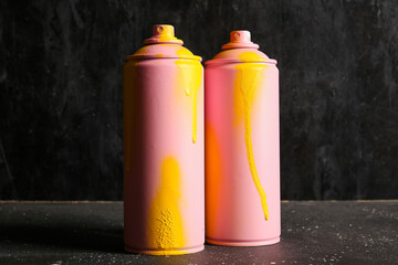 Spray paint cans on black background