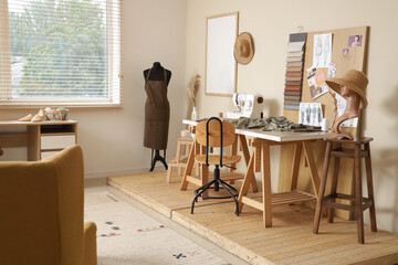 Interior of stylish atelier with tailor's workspace, mannequin and mood board