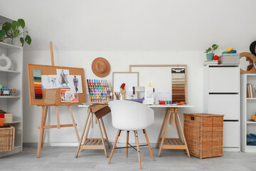 Interior of fashion designer's studio with workplace and drawings