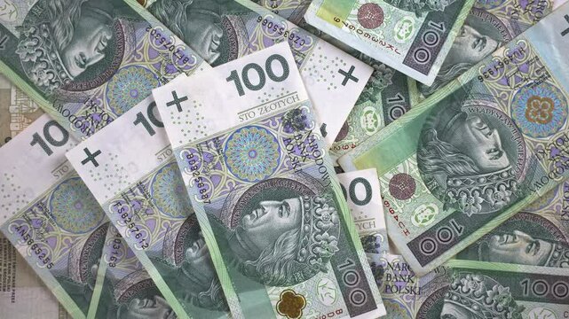 A close-up view of falling Polish banknotes. Stacking 100 zloty notes in a pile.