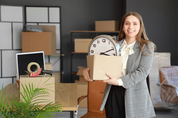 Young businesswoman with cardboard box in office on moving day