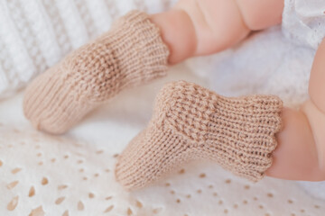 Baby feet in cozy knitted booties resting on a soft blanket during a peaceful afternoon