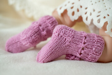 Adorable handmade pink baby booties on a soft blanket, showcasing delicate craftsmanship and warmth perfect for chilly days