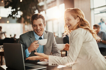 Businessman and businesswoman having coffee during a meeting in a cafe bar decorated for christmas and the new years holidays