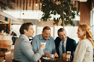 Fototapeta premium Group of business people having coffee and talking in a cafe decorated for the christmas and new year holidays