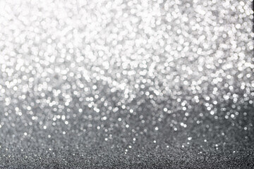 Metallic foil background. Shiny metal silver foil texture abstract defocused background. Sparkle glitter texture with bokeh lights. Holiday Christmas image.